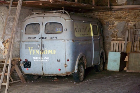 Deep in the darkness of a garage that was open to the street - a prehistoric after sales service van!